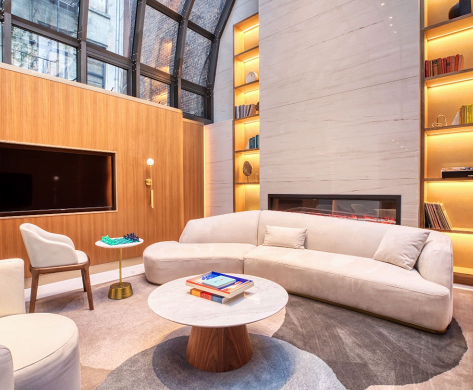 a lounge with seating table bookshelf and tv
