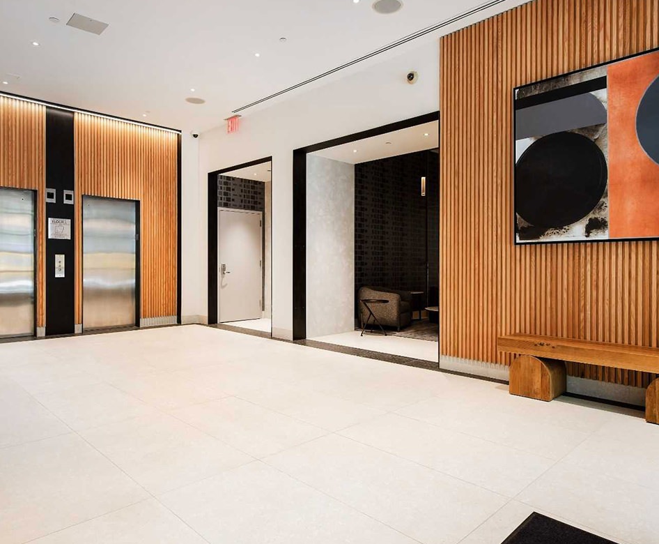 a lobby with seating tv and elevators